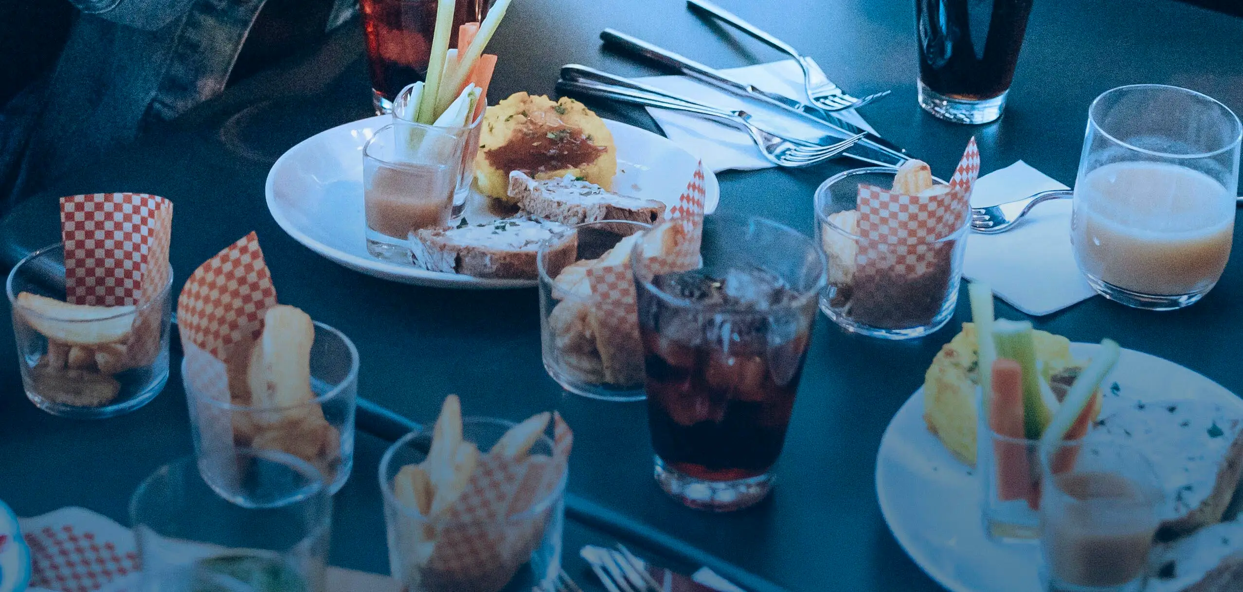 Friends taking photos of their food and drinks at outdoor cafe,